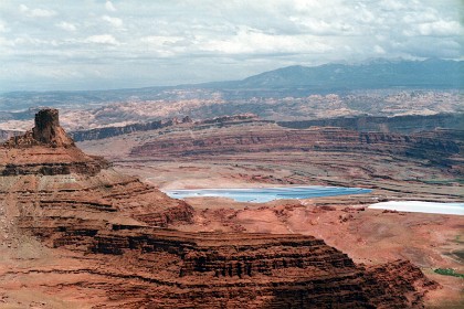 These blue areas are potash (Potassium chloride) evaporation ponds. Miners pump water from the Colorado River deep underground to reach the potash ore 3,900 feet below the surface. The water dissolves the soluble potash into a brine, which is then pumped into underground caverns. Once it is fully dissolved, the potash brine is pumped to one of the evaporation ponds.