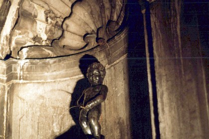 This is the Manneken Pis (Dutch for 'Little Pissing Man').  It is a landmark bronze fountain sculpture in central Brussels, depicting a puer mingens or naked little boy urinating into the fountain's basin. The current statue is a replica which dates from 1965. The original is kept in the Brussels City Museum. Manneken Pis is approximately five minutes' walk from the Grand Place (Brussels' main square),