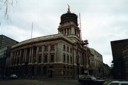 The Central Criminal Court of England and Wales, commonly referred to as the Old Bailey after the street on which it stands, is a criminal court building in central London. The street outside follows the route of the ancient wall around the City of London, which was part of the fortification's bailey, hence the metonymic name.   Metonymic:&nbsp;figure of speech in which the name of an object or concept is replaced with a word closely related to or suggested by the original, as “crown” to mean “king”