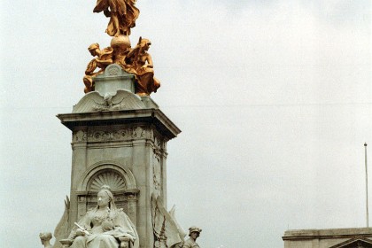 This is the Queen Victoria Monument situated outside of Buckingham Palace. At the top of the central pylon stands a gilded bronze Winged Victory, standing on a globe and with a victor's palm in one hand. Beneath her are personifications of Constancy, holding a compass with its needle pointing true north, and Courage, holding a club. Beneath these, on the eastern and western sides, are two eagles with wings outspread, representing Empire. Below these, statues of an enthroned Queen Victoria (facing The Mall) and of Motherhood (facing Buckingham Palace), with Justice (facing north-west towards Green Park) and Truth (facing south east). These were created from solid blocks of marble, with Truth being sculpted from a block weighing 40 tonnes