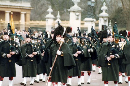 These are probably the Scots Guards.  It's hard to tell but bagpipes and their three stripes might signify their third place ranking. Tartan garters maybe?  The badges seem to be the Thistle emblems.