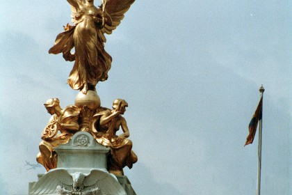 The Victoria Monument outside of Buckingham Palace. At the top of the central pylon stands a gilded bronze Winged Victory, standing on a globe and with a victor's palm in one hand.