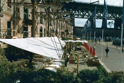 These are restaurants in the old wool stores. The road is now a pedestrian plaza instead of docks where the wool ships once loaded and unloaded.