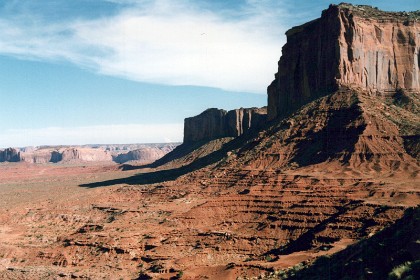 Monument Valley is part of the Colorado Plateau. The elevation of the valley floor ranges from 5,000 to 6,000 feet  above sea level. The floor is largely siltstone of the Cutler Group, or sand derived from it, deposited by the meandering rivers that carved the valley. The valley's vivid red color comes from iron oxide exposed in the weathered siltstone. The darker, blue-gray rocks in the valley get their color from manganese oxide.