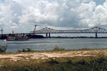 A genuine diesel-powered paddle wheeler, the Creole Queen,  motors toward the Gulf of Mexico. The Creole Queen is a 1,000-passenger paddlewheel riverboat operating out of the Port of New Orleans. It was built by Halter Marine at Moss Point, Mississippi along the lines of a turn-of-the-century sternwheeler and was commissioned  in September 1983. That is, it's  almost new.  The Creole Queen is an authentic paddle wheeler, but is powered by a diesel electric system rather than by steam.