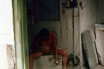 A stone mason hand carves headstones.