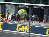 MotoGP Pit Lane Photographer after an interesting angle. The lady on the left looks to be unimpressed.