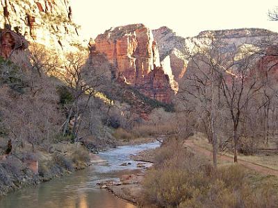 The sun rises in the canyon.  There are many walking trails in the park but in designated areas to protect this magnificent asset. The trees beside the river are Fremont Cottonwoods planted to control erosion