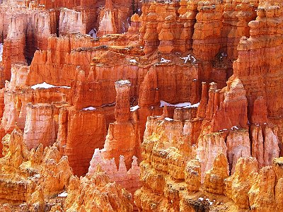 In addition to frost wedging, rain also sculpts the hoodoos. Even the crystal clear air of Bryce Canyon creates slightly acidic rainwater (weak carbonic acid) that can slowly dissolve limestone grain by grain. It is this process that rounds the edges of hoodoos and gives them their lumpy and bulging profiles. Where internal mudstone and siltstone layers interrupt the limestone, the rock is more resistant to the chemical weathering because of the comparative lack of limestone.