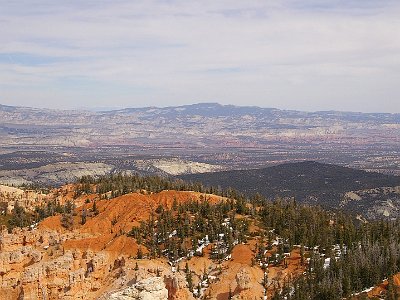 The brochure says that you can see Navajo Mountain 130 kms away from Rainbow Point. I think that's Navajo Mountain faintly visible in the far distance in about 1/3 from the left centre.  It's actually on the other side of Lake Powell in Utah a few miles north of the Arizona border.