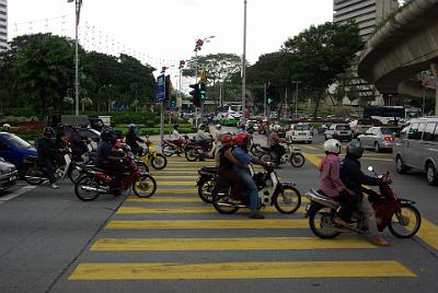 MONDAY 20 OCTOBER 2008   Notice that the pedestrian light is green but the crossing is occupied by motorcycles. If you were to get half way across when the lights changed, you'd be run down as hundreds of motorcycles moved off in unison.  Crossing streets in KL is fraught with peril.      Next: Tamin Tasik Park