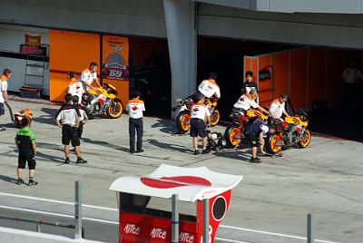 SUNDAY 19 OCTOBER 2008 - RACE DAY  The Repsol Honda 'team' preparing for morning warmup. They have a wall (visible in the background) down the middle of the garage so that neither rider can see the other's information.