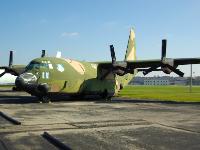 The LOCKHEED AC-130A HERCULES was originally designed as an assault transport capable of operating from unpaved, hastily prepared airstrips. The Hercules made its first flight in 1954 and by 1976 more than 1,200 C-130s had been ordered.  The C-130 could transport up to 92 combat troops and their gear or 45,000 pounds of cargo. Where facilities were inadequate, the Hercules could deliver its cargo by parachute or by low altitude ground-cable extraction. : 2009-11-04 USA Air Force Museum