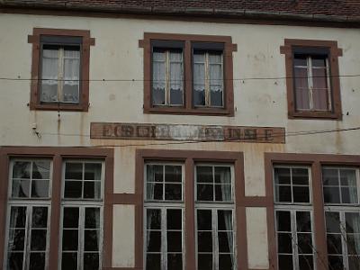 Friday 2009-04-03&nbsp;&nbsp;&nbsp;   Walking tour of Romanswiller  As Alsace changed from German to French, the spelling of this sign at the Romanswiller School changed also.