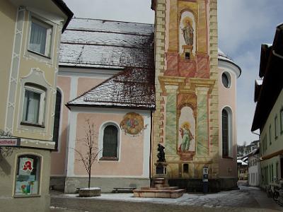 Monday 2009-03-30&nbsp;&nbsp;&nbsp;   Mittenwald   The most significant landmark in the village is the pink colored Roman Catholic church of Saints Peter and Paul. The statue in front is of Mathias Kloz who established Mittenwald's violin-making craft in 1715. The museum is down the small alley to the right.