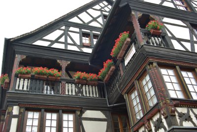 Tuesday 15  June, 2010  This beautiful building features highly decorative, carved wooden posts and beams. Geranium planter boxes are one of many attractive features of the buildings in Kaysersberg. : 2010-06-15 voges