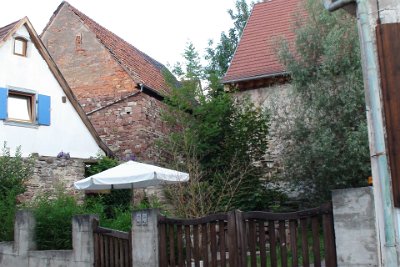 Tuesday 6 July, 2010 &nbsp;  What stories these buildings could tell. The building on the left has a modern first storey added on top of its original stone ground floor. The building in the centre has had a roof added,  perhaps centuries after the original stone foundation was laid. The stones are pink,  the same as the Strasbourg cathedral, and have been sawn. The top floor addition is made from moulded bricks and the plaster is falling off.  The rightmost building is also built from stones, heavily mortared,  but a modern roof has been added. : 2010-07-05 JGR BLACK FOREST