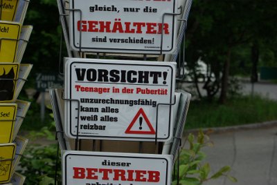 Thursday 1 July, 2010  We park the car in the visitor's parking area and see this amusing sign at the gift store.  Caution! Teenager in puberty • Of unsound mind • Can do everything • Knows everything • Sensitive, irritable : 2010-07-01 partnach-lindenberg