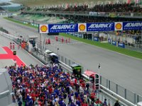 Sunday 13 October 2013 - Race day  One of the Ducati riders pulls a stoppie at the end of his lap while next group go through the gates to meet their fate. : Sepang