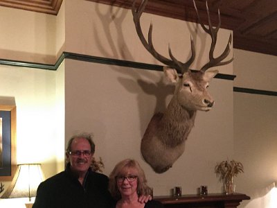 Day 6 - 40th Anniversary trip to NZ  After our meal, we visit the (non-) smoking room; wood panelled, fire place, very British country gentlemen's, blokey kind of place. We are thrilled when a staff member takes a picture of us posing beneath the trophy of Bambi.