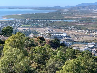 In front is the is the  Queensland Country Bank Stadium , home of the  North Queensland Cowboys  Rugby League team. Ross Creek (where shark attacks have been recorded) is visible in front of the stadium and the large river in the background is the Ross River.